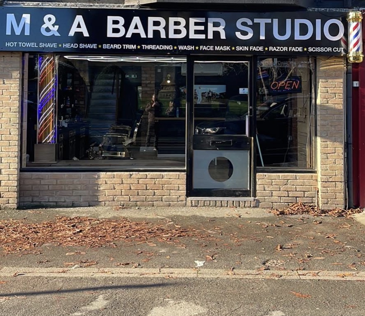 Exterior of M&A Barber Studio on Church Road with signage and barber pole
