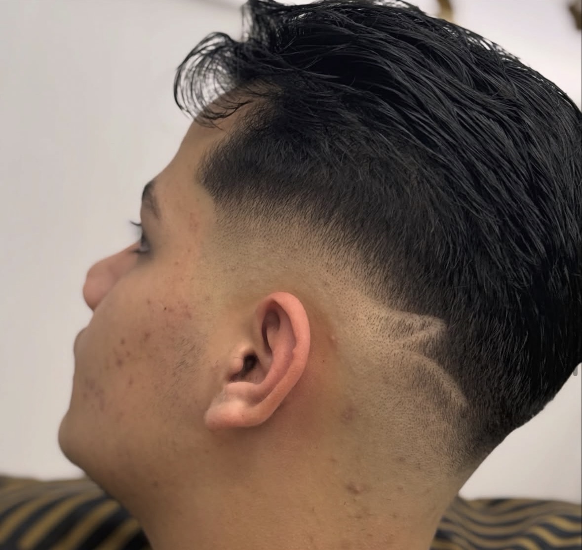 Sharp skin fade with a lightning bolt design shaved into the side
